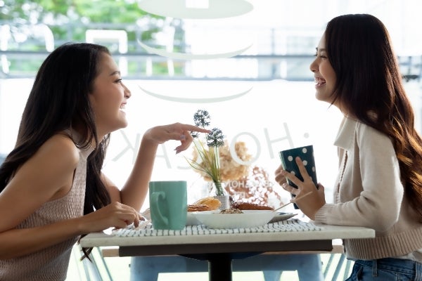 Two colleagues collaborating at a laptop in a bright workspace
