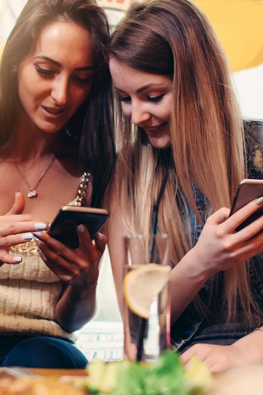 Three women having an authentic conversation in a bright, modern space
